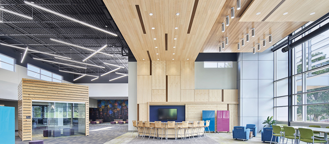 Modern educational facility with downlights, cylinders, and continuous suspended products.